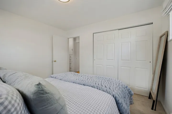 White paneled closet doors, neutral wall paint, and recessed lighting