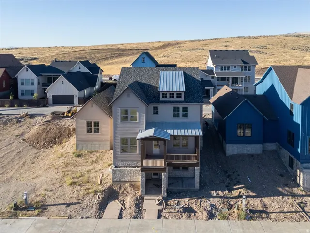 Newly constructed residence featuring a stone and siding exterior, a covered porch, and a metal roof accent