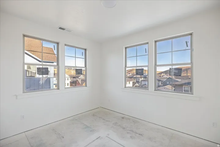 Four grid-pattern windows, white walls, and a single ceiling-mounted light fixture
