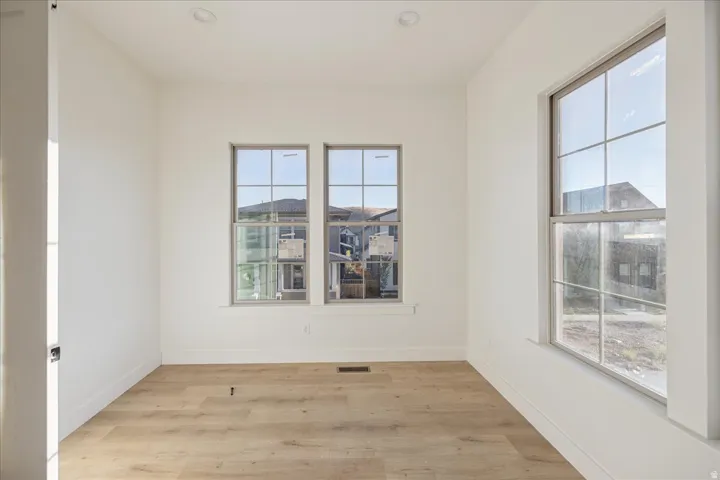 Wood-finish flooring, recessed lighting, and multiple windows