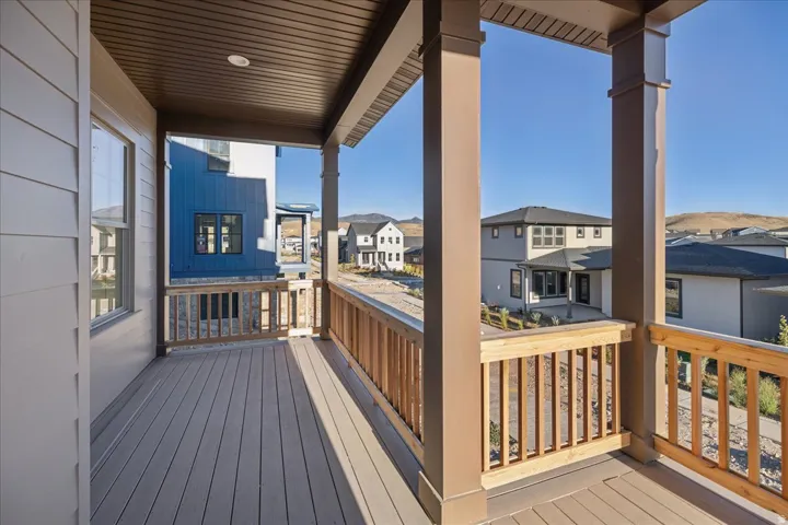 Covered outdoor deck with composite decking, wood railing, and recessed lighting