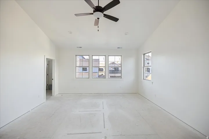 Vaulted ceiling with a ceiling fan, recessed lighting, and multiple windows