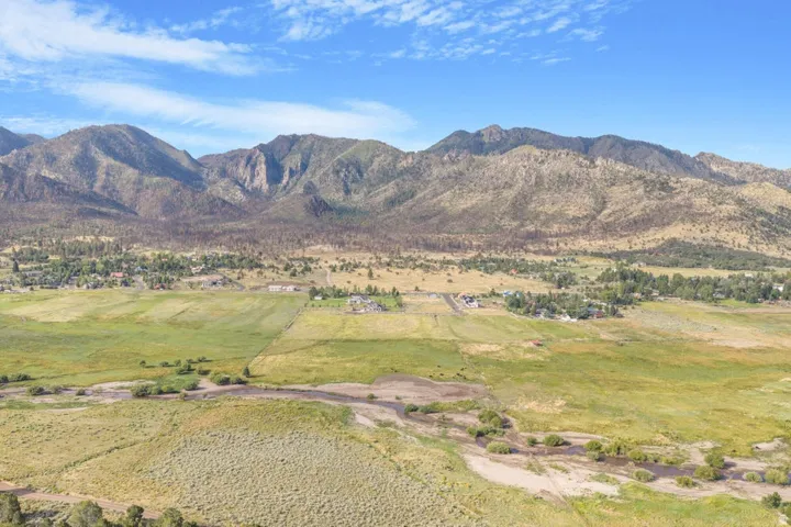 Expansive undeveloped land with natural vegetation and distant mountain ranges
