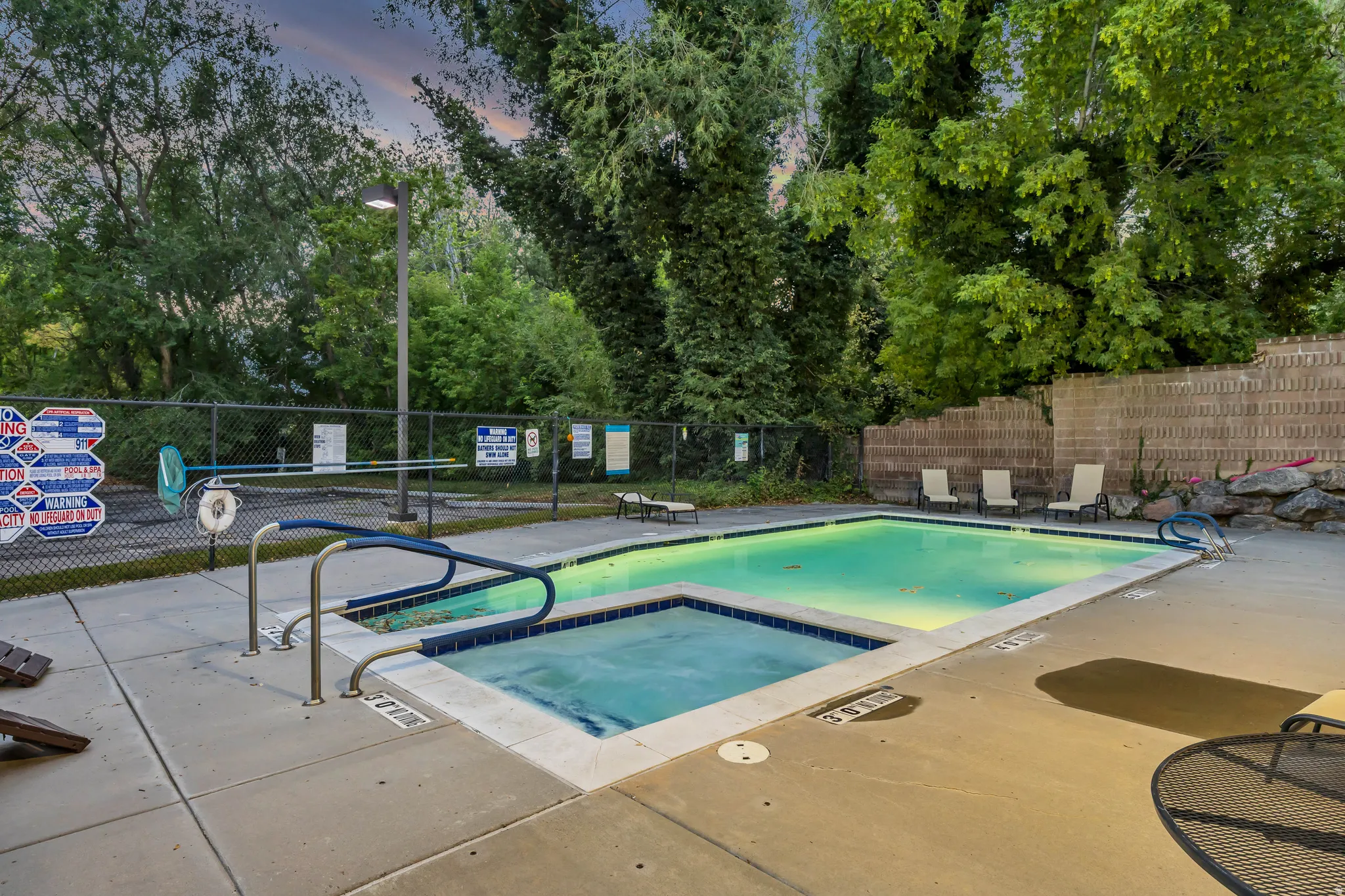 Swimming pool with integrated spa and surrounding concrete decking