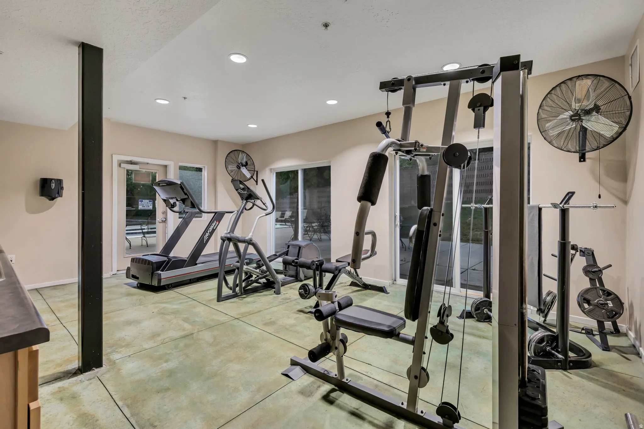 Fitness room featuring recessed lighting, a wall-mounted fan, and sliding glass doors