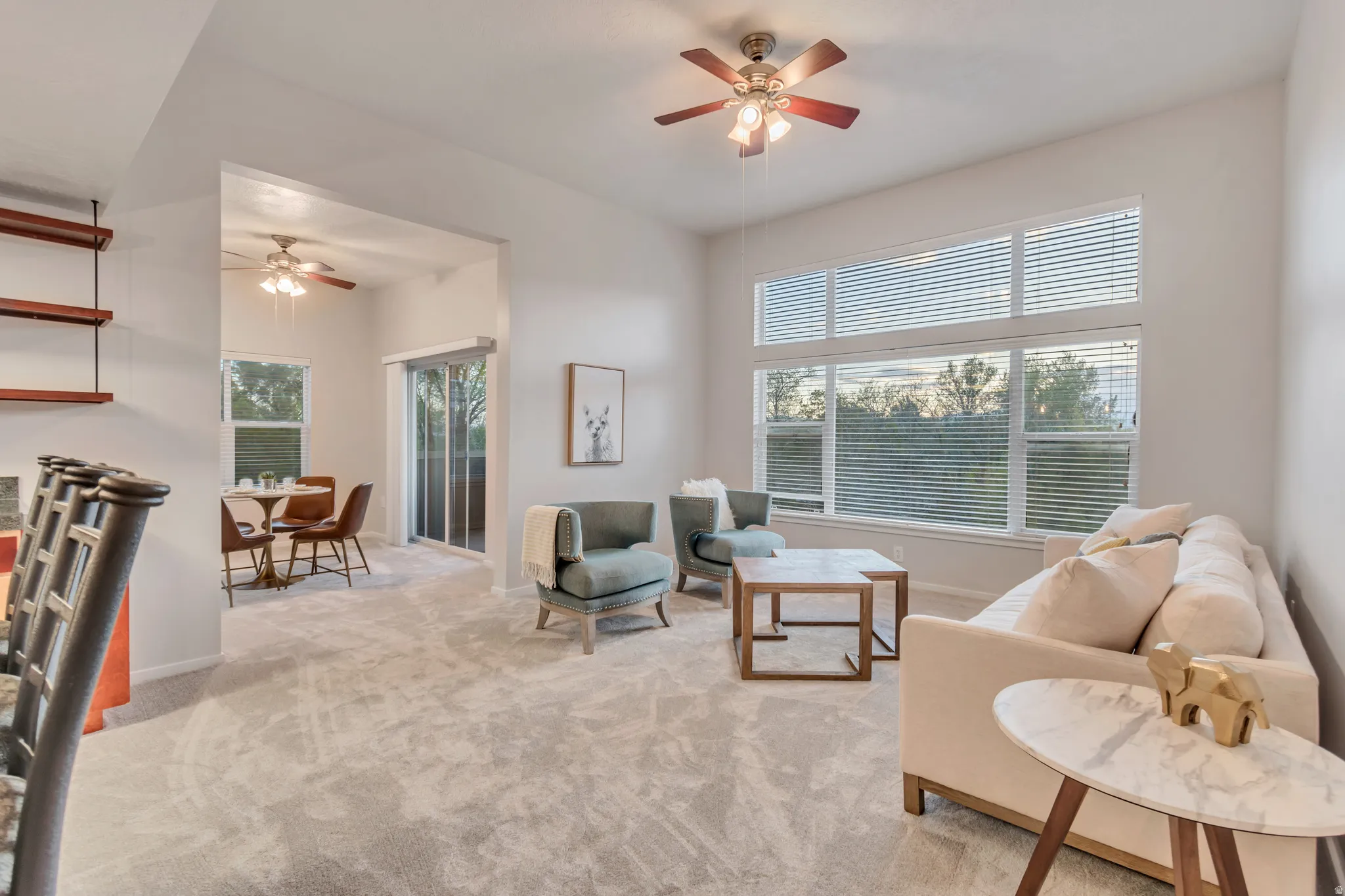 Vaulted ceilings, large picture windows, and a ceiling fan with light fixture