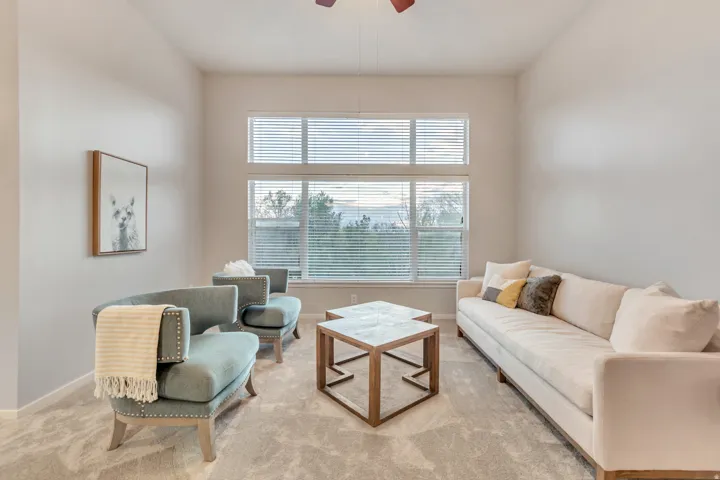 High ceilings with a ceiling fan, wall-to-wall carpeting, and a large window with horizontal blinds