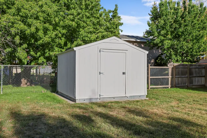 Outdoor storage shed, chain-link fencing, and wood panel fencing