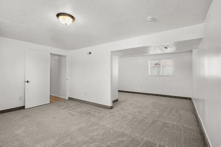 Recessed window with white trim, gray wall-to-wall carpeting, and a flush mount ceiling light fixture
