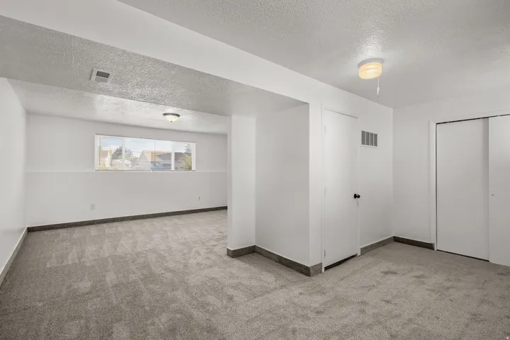 Recessed window with exterior views, overhead lighting, and grey carpeting