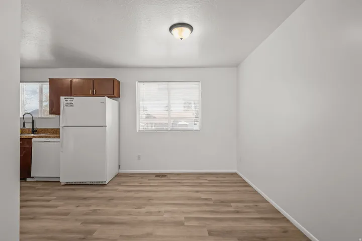Light wood-finish flooring, white walls, and a recessed ceiling light