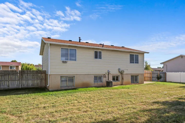 Expansive yard space with a wood privacy fence and a tan siding exterior