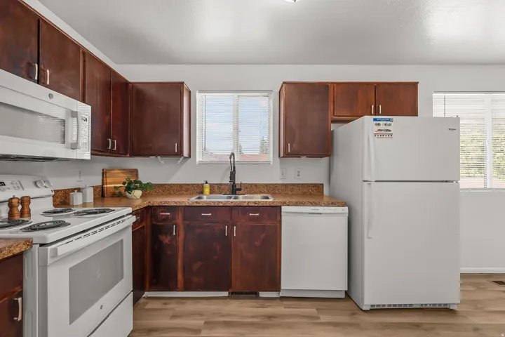 Kitchen featuring wood-finish cabinetry, light-toned countertops, and wood-finish flooring
