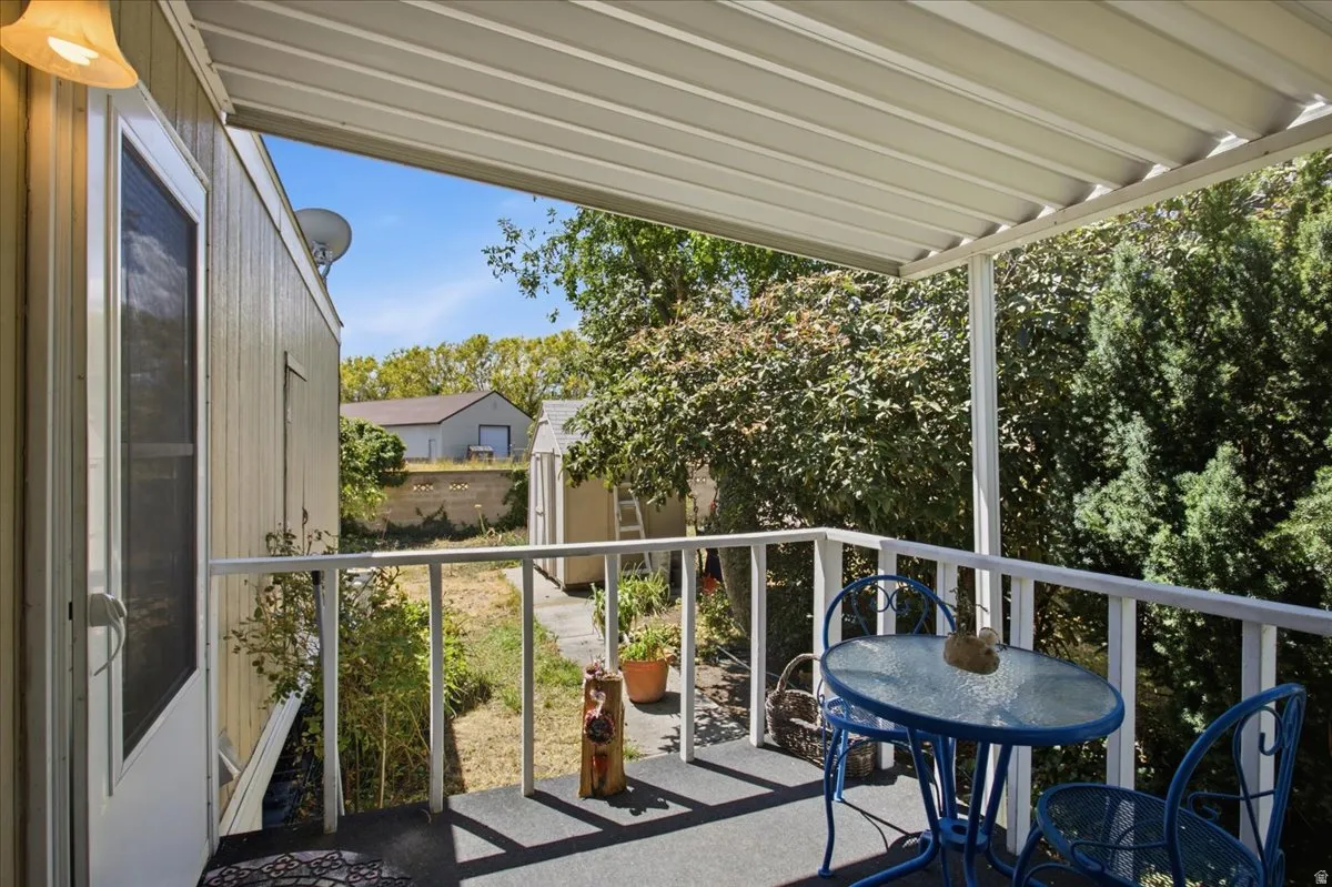 Covered outdoor patio with a metal awning and white railing