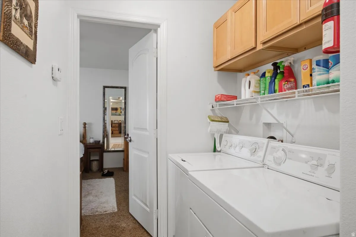Laundry area featuring wood-finish cabinetry, wire shelving, and overhead lighting