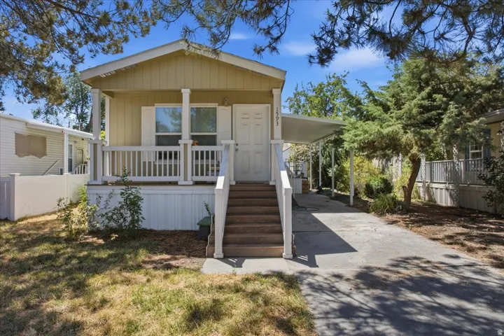 Covered front porch with white railings and columns, providing a welcoming entry