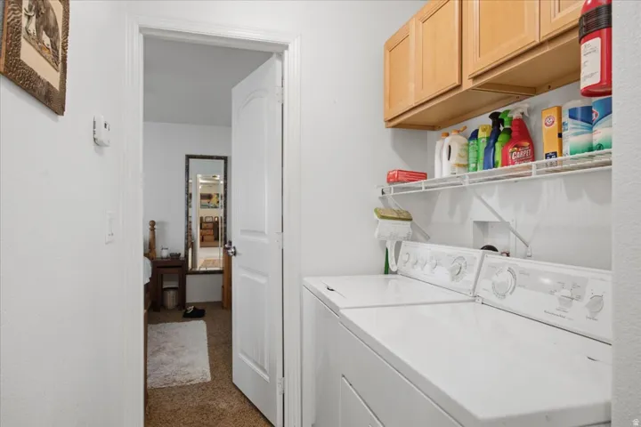 Laundry area featuring wood-finish cabinetry, wire shelving, and overhead lighting