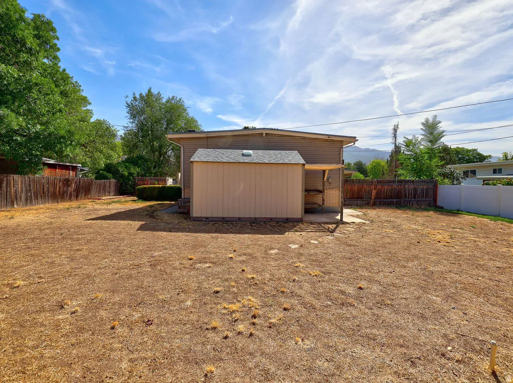 Expansive yard with a storage shed and a covered patio area