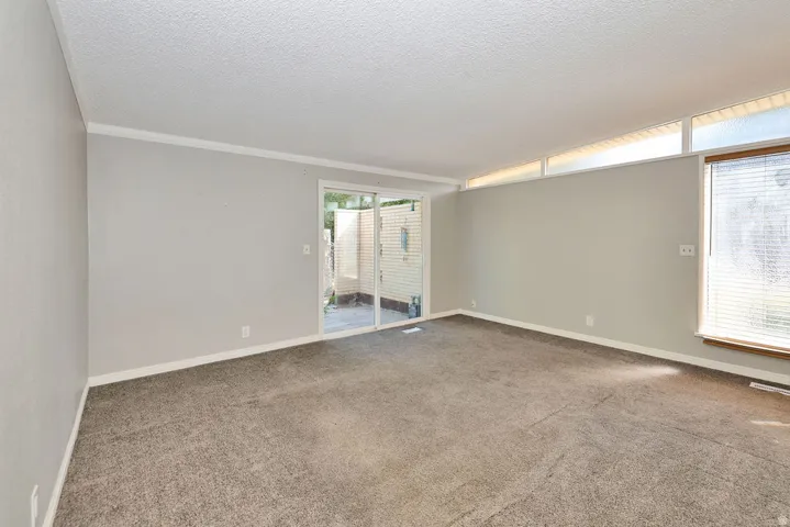 Sliding glass door, wall-to-wall carpeting, white trim, and transom windows