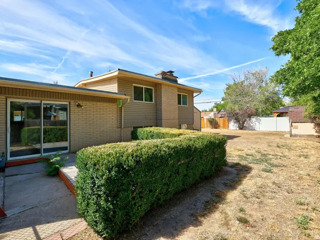 Rear exterior featuring siding, brick accents, and a sliding glass door