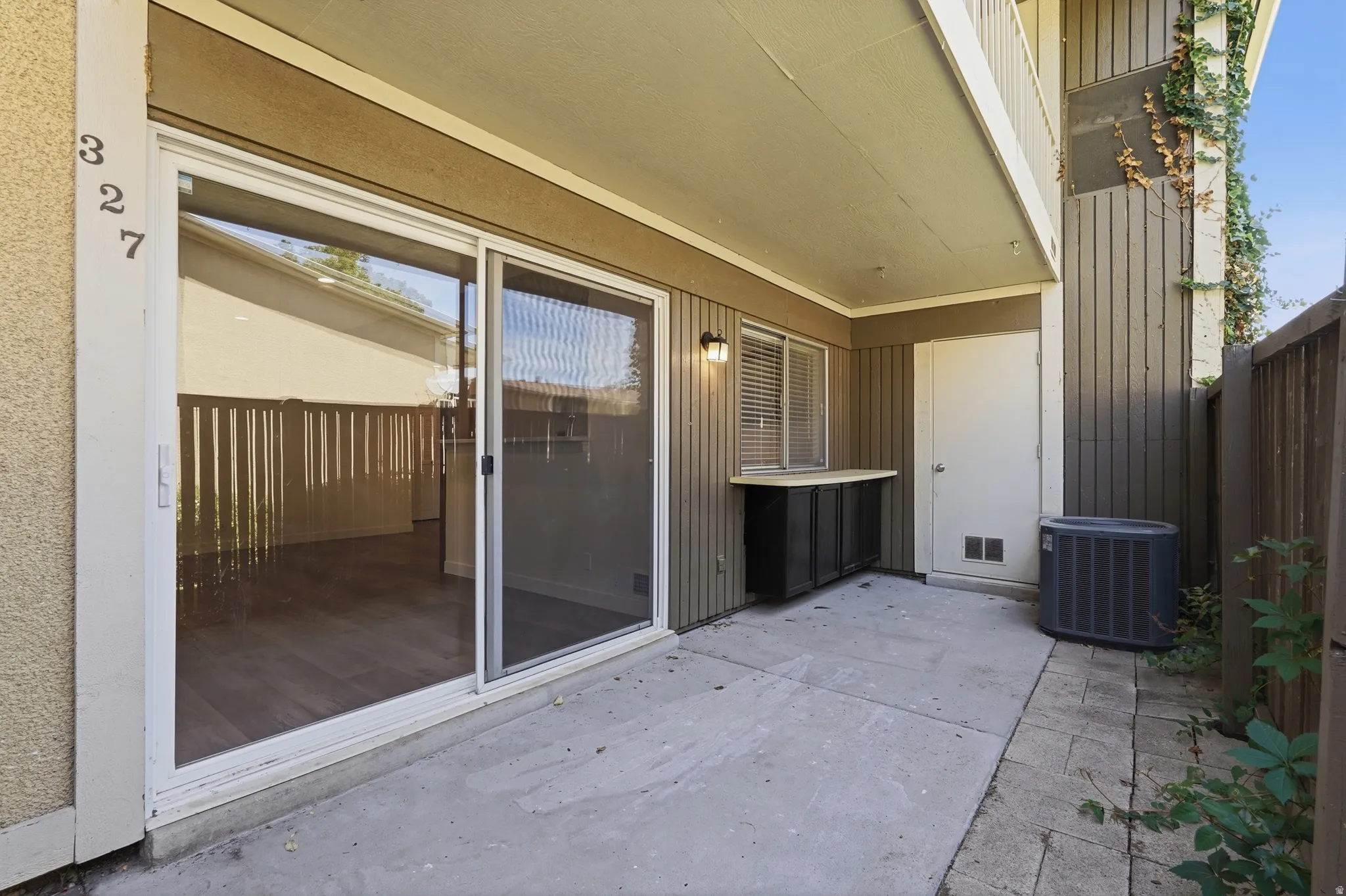 Ground-level patio featuring concrete hardscaping, an integrated storage cabinet with a counter, and a privacy fence