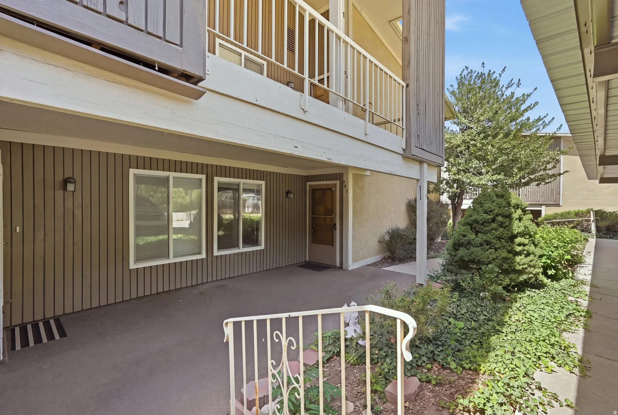 Ground-floor entry with multi-pane windows and exterior wall sconces