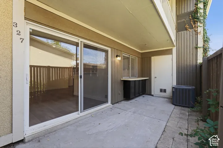 Ground-level patio featuring concrete hardscaping, an integrated storage cabinet with a counter, and a privacy fence