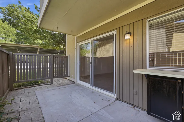 Private patio featuring a concrete slab and paver stone hardscaping