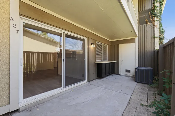 Ground-level patio featuring concrete hardscaping, an integrated storage cabinet with a counter, and a privacy fence