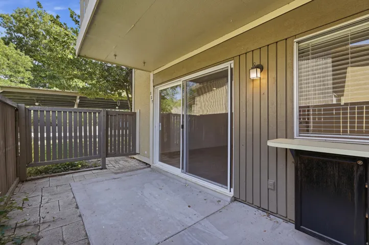 Private patio featuring a concrete slab and paver stone hardscaping