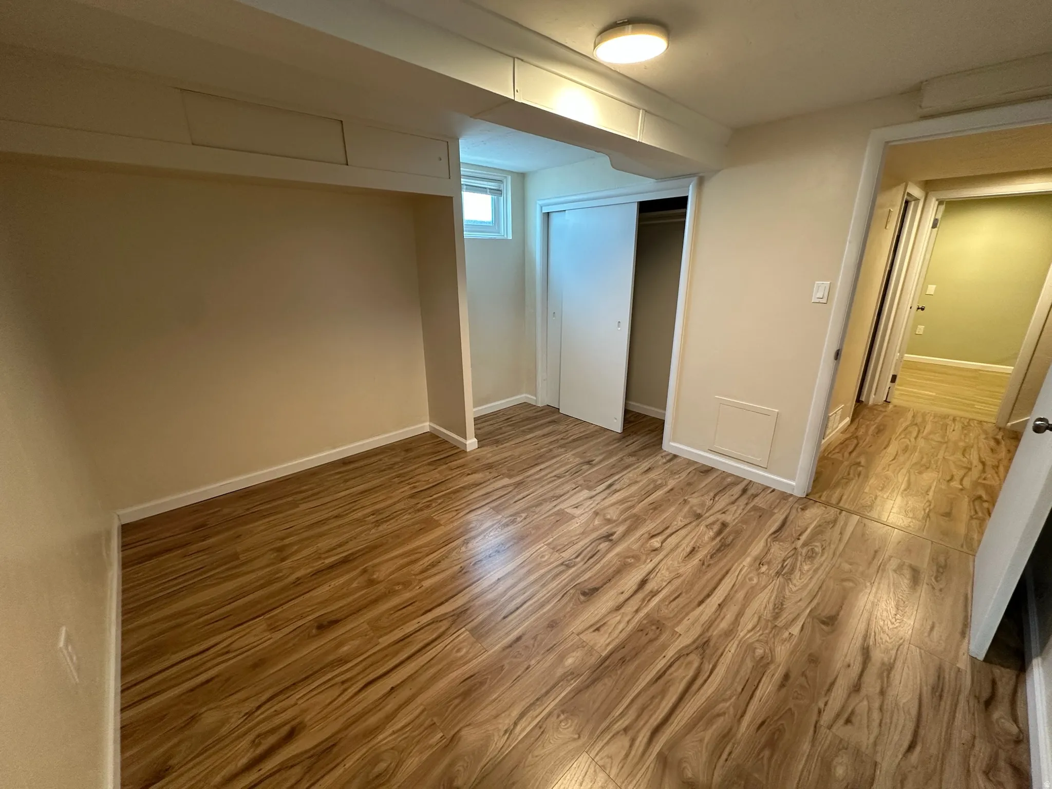 Wood-finish flooring, recessed window, and sliding closet doors