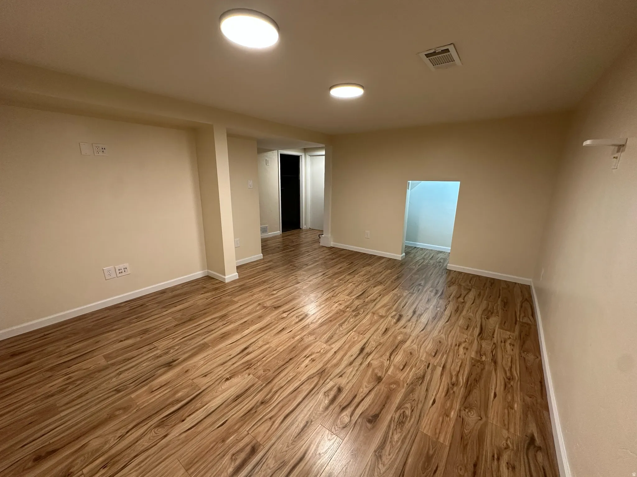 Wood-finish flooring, recessed ceiling lighting, light-toned walls, and white trim