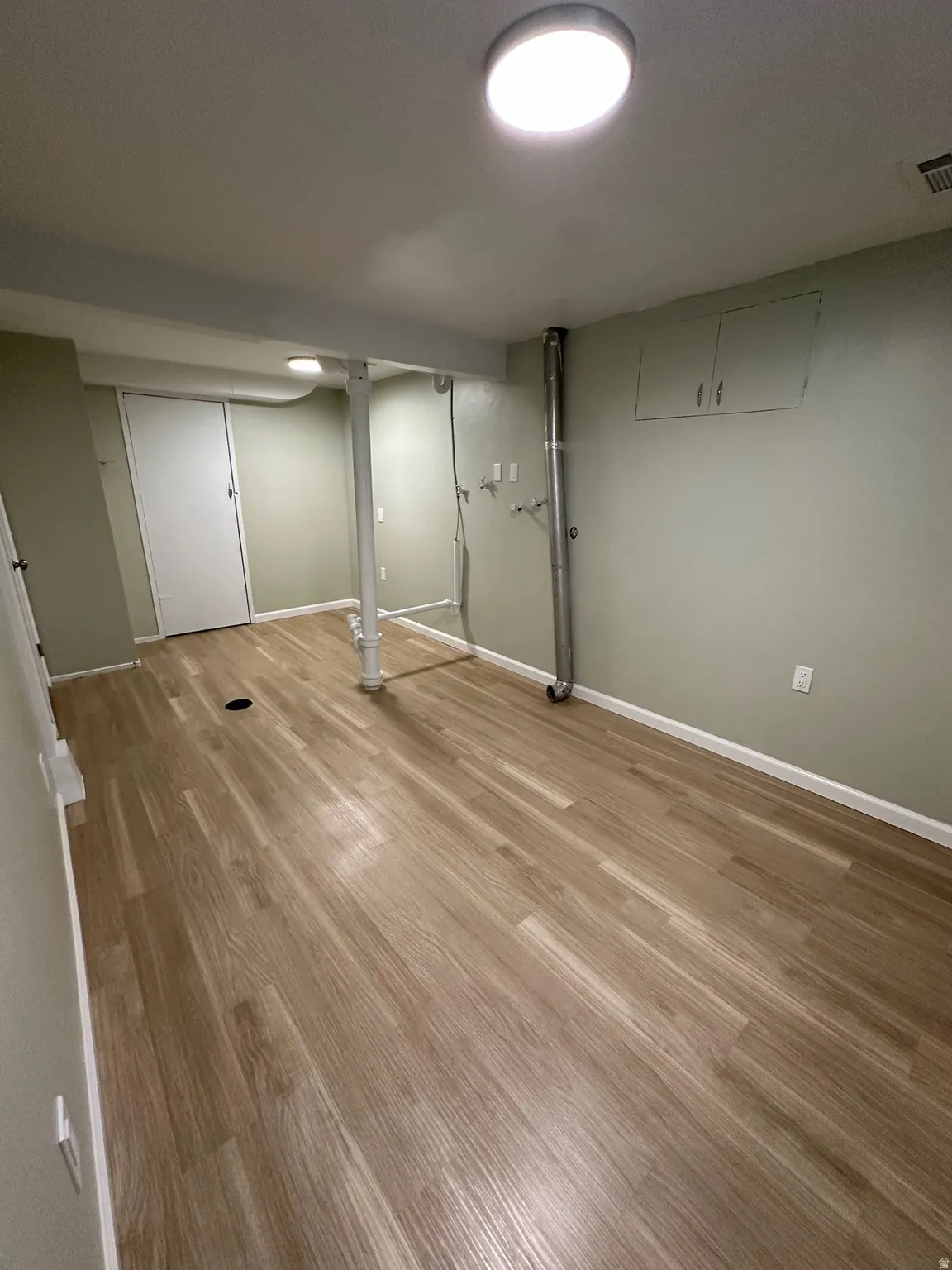 Recessed ceiling lights illuminate wood-finish flooring