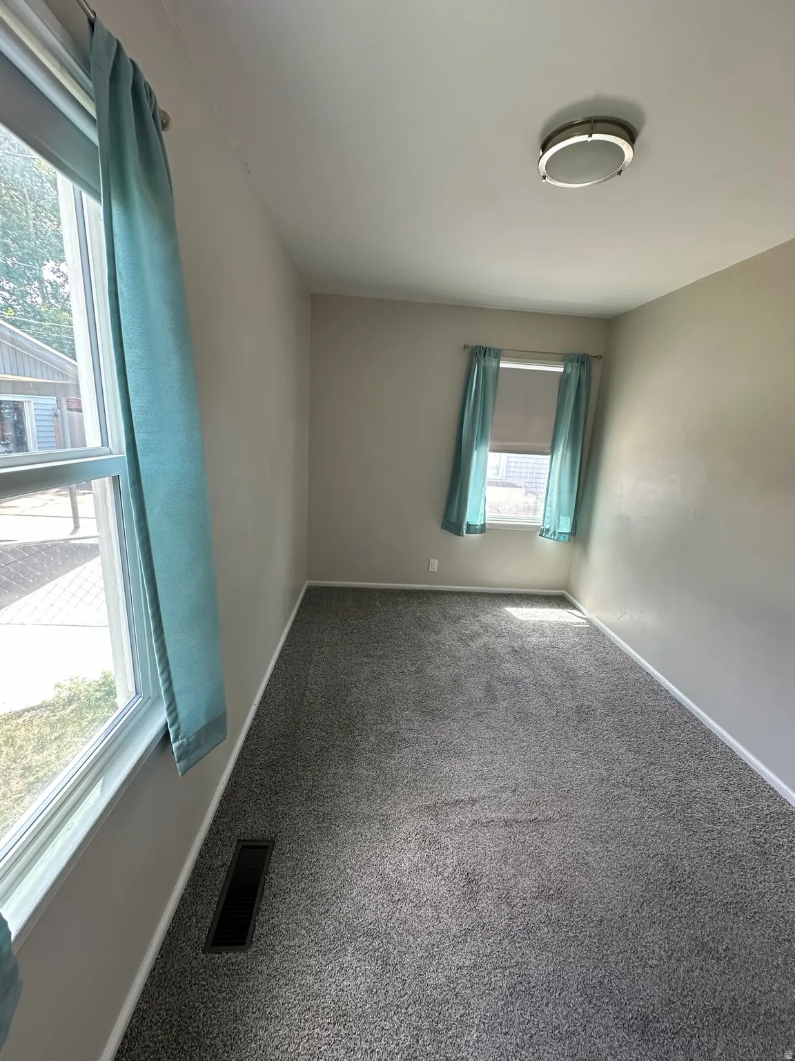 Plush gray carpeting with light gray wall paint and a flush-mounted ceiling light fixture
