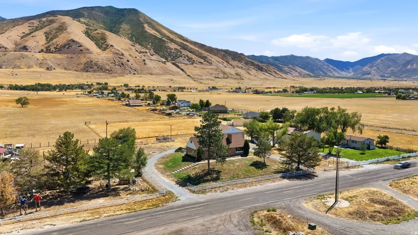 Rural property with mountain scenery, expansive open fields, and residential structures