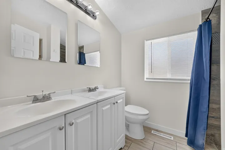 Dual vanity with white cabinetry, square undermount sinks, and chrome faucets