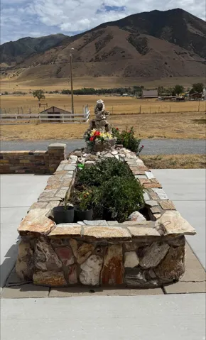 Stone-clad planter box with integrated landscaping