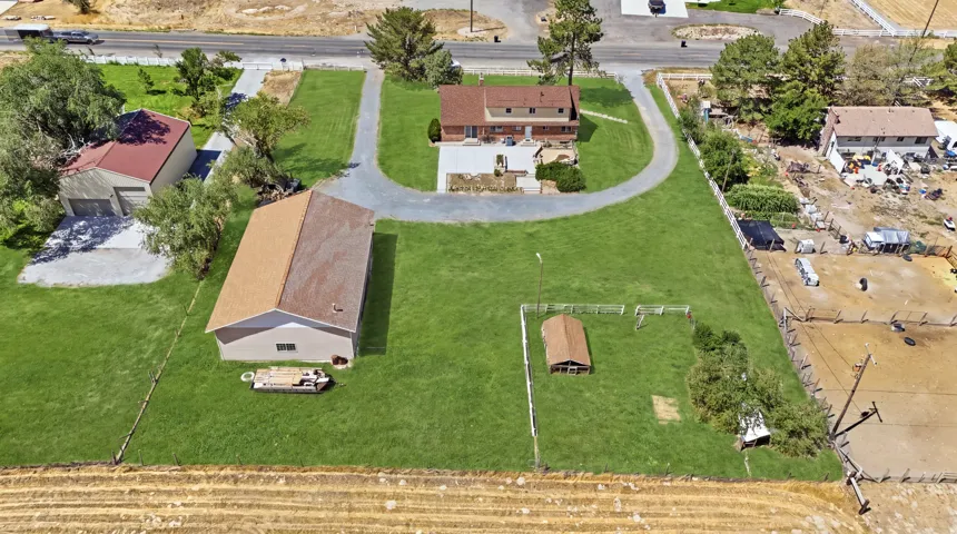 Expansive property featuring a main residence, detached garage, separate outbuilding, and a fenced enclosure