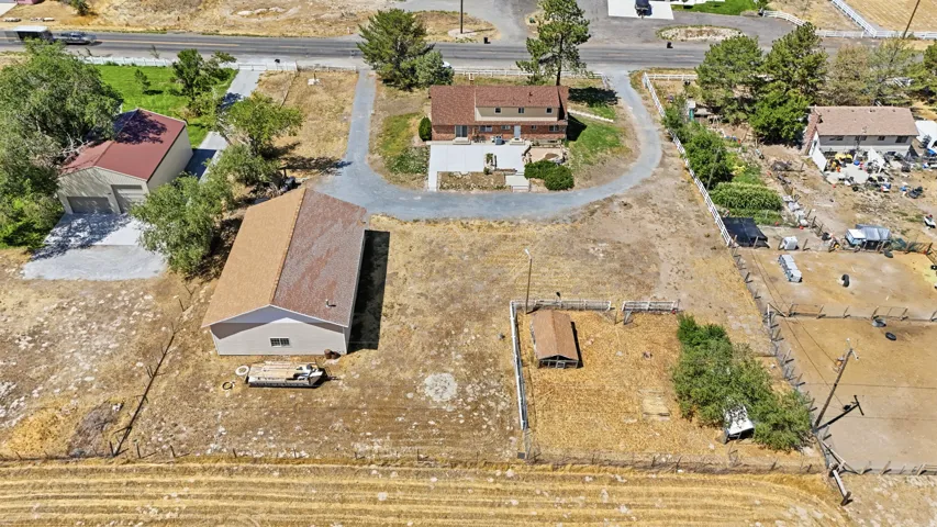 Main residence with a light brown shingle roof, accompanied by a detached garage and an additional auxiliary building with a light brown shingle roof