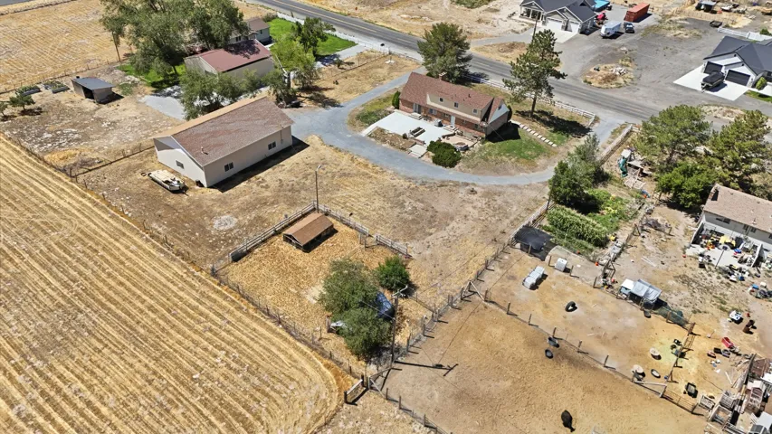 Expansive property featuring a main residence, a large detached garage, and fenced outdoor areas