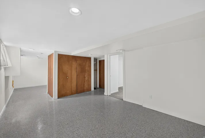 Recessed lighting, wood-finish closet doors, and light gray flooring