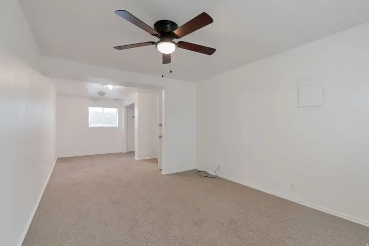 Ceiling fan with integrated lighting, neutral-toned carpet flooring, white painted walls, and window with horizontal blinds