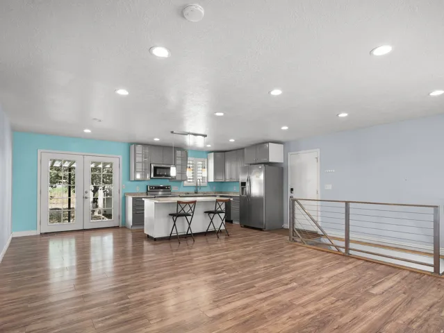 Open concept living area featuring wood-finish flooring, recessed lighting, and a modern kitchen