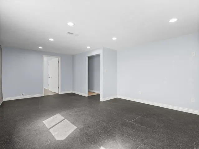 Recessed lighting, light gray walls, dark flooring, white baseboards, and white trim