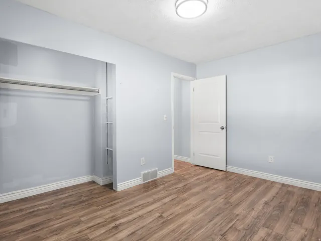 Wood-finish flooring, light gray wall paint, and white trim accents