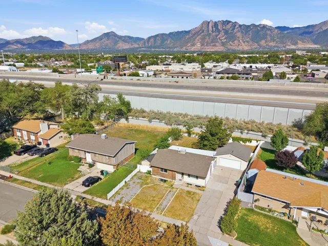 Mountain backdrop, established neighborhood setting, paved driveway, attached garage, and mature trees