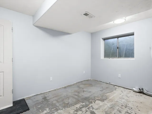 Neutral gray walls, white ceiling, flush-mount ceiling light, single window, and a white interior door
