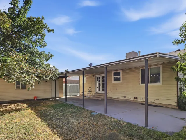 Expansive concrete patio with a full-length metal awning, providing extensive covered outdoor space