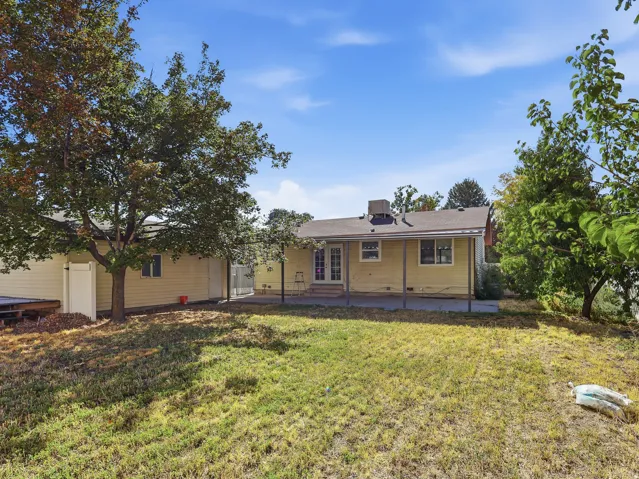 Expansive backyard with a covered patio and direct access to the interior via double French doors