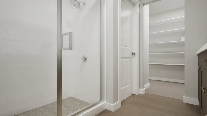 Glass-enclosed shower with subway tile surround, tiled shower floor, and brushed nickel fixtures